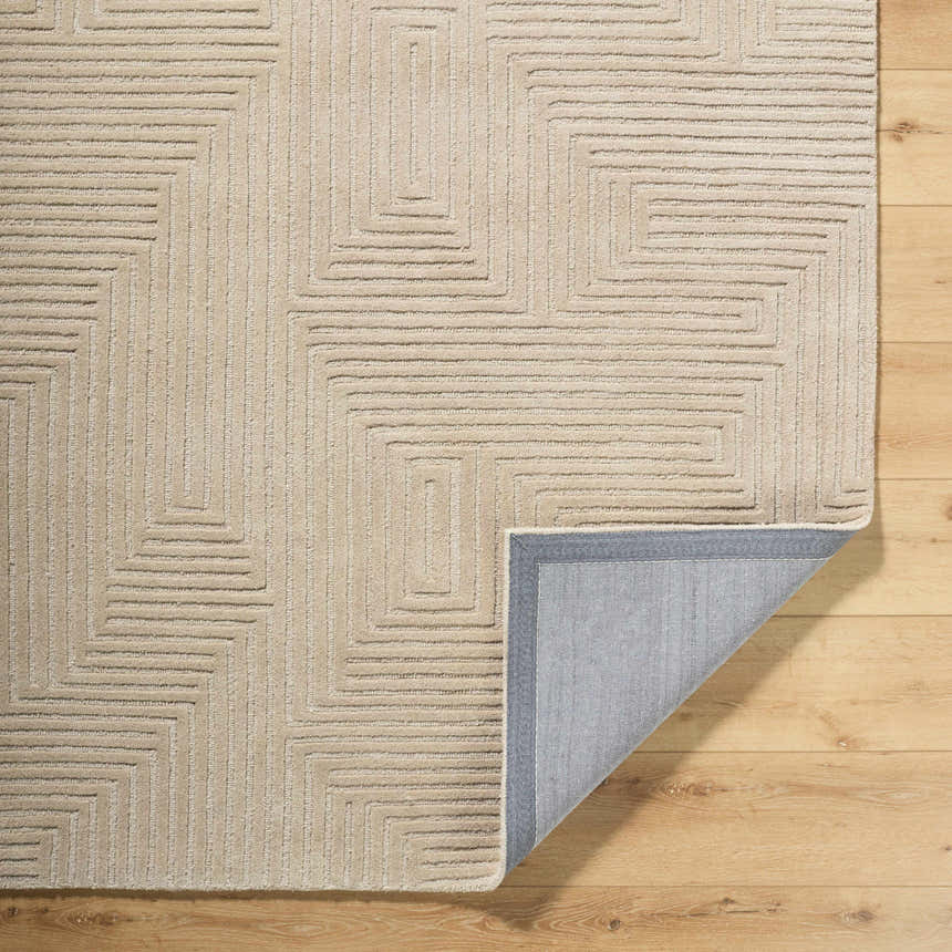 Close-up of the hand-tufted Citro Ivory Area Rug. Contemporary wool rug with a geometric maze pattern. Fold