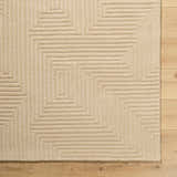 Close-up of the hand-tufted Citro Beige Area Rug showing geometric pattern and textured wool on a wood floor. Corner