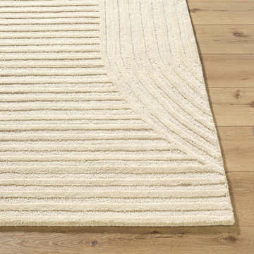 Close up of the hand-tufted Whan Ivory Area Rug showing its geometric line pattern and wool texture on wood floor. Front
