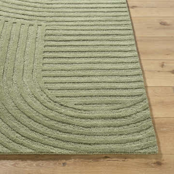Close-up of the hand-tufted Whan Sage Area Rug. Features a contemporary linear and curved design in a soft sage green wool. Front