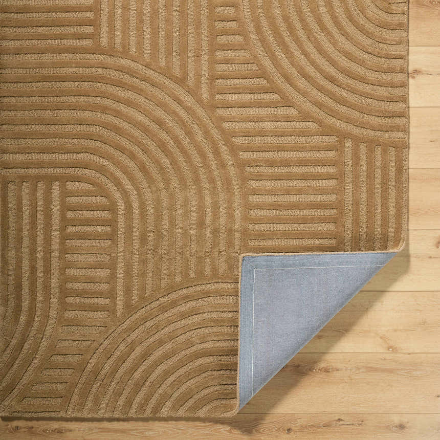 Close-up of the hand-tufted Whan Camel Area Rug showing its geometric pattern and texture. 100% Wool rug with folded corner. Fold