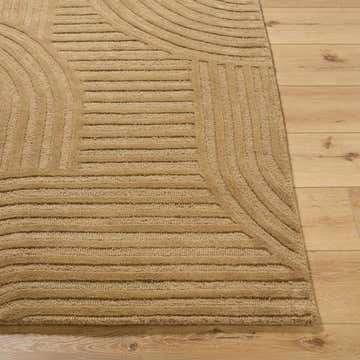 Close-up of the hand-tufted Whan Camel Area Rug showing its geometric pattern and textured wool on wood floor. Front