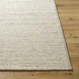 Close-up of the hand woven Ayumu Sandstone Area Rug, a wool rug in ivory, sandstone, and taupe, on hardwood floor. Front