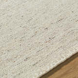 Close-up of the hand woven Ayumu Sandstone Area Rug. Ivory, sandstone, and taupe wool fibers create a textured, neutral design. Texture