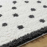 Close-up of the Chaia Dotted Black & White Plush Rug, showing the shag texture and dotted pattern. Texture