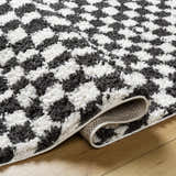 Close-up of the Kieu Black & White Checkered Shag Rug showing its plush texture and geometric pattern. Fold