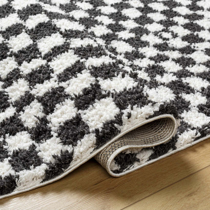 Close-up of the Kieu Black & White Checkered Shag Rug showing its plush texture and geometric pattern. Fold