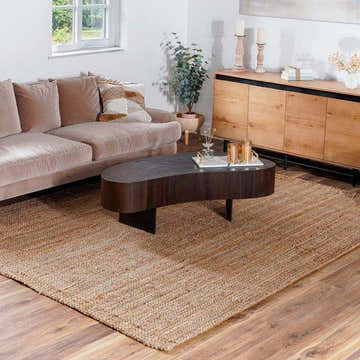 Living room scene with a brown sofa and Ambel Chocolate Brown Camel Jute Area Rug on a wood floor. Roomscene-Rectangle