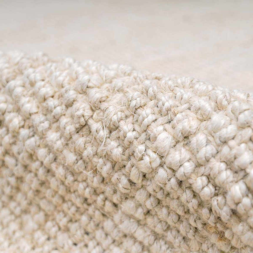 Close-up of the hand-woven Ambel Cream Jute Rug showing its natural jute texture and bone color. Fold