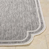 Close-up of Arnola Gray Outdoor Rug showing charcoal, cream, and gray woven texture and decorative edge. Front