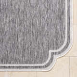 Close-up of Arnola Gray Outdoor Rug showing charcoal and cream fibers and a traditional farmhouse border. Corner
