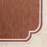 Close-up of the Arnola Brown Outdoor Rug showing the woven texture and cream border detail. Corner
