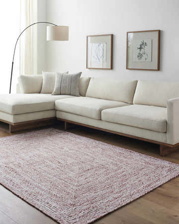 Living room scene with a Kenyi Rust Area Rug, cream sectional sofa, wood floors, and modern art. Roomscene-Rectangle