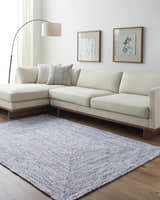 Living room with a Kenyi Navy Area Rug, a white sectional sofa, and modern wall art. Roomscene-Rectangle