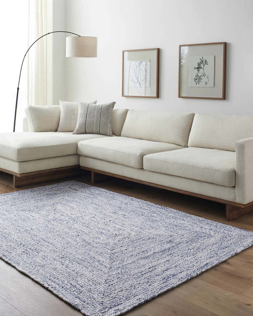Living room with a Kenyi Navy Area Rug, a white sectional sofa, and modern wall art. Roomscene-Rectangle