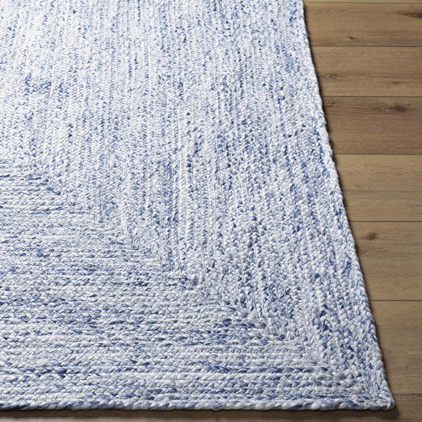Close up of Kenyi Navy Area Rug showing hand woven texture and navy and white color on wood floor. Front