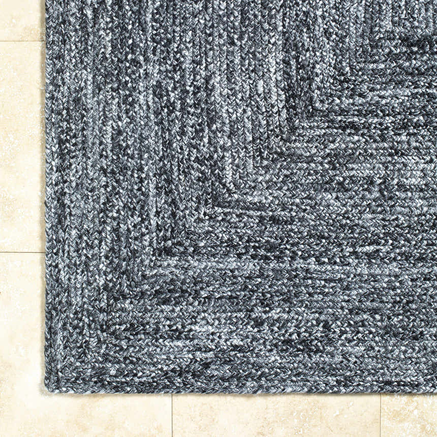Close-up of the hand-woven Kenyi Black Area Rug showing its black and white yarn and textured, contemporary design. Corner