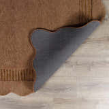 Close-up of the brown Gurib Border Modern Hand Tufted Wool Area Rug showing texture, backing, and scalloped edge. Fold
