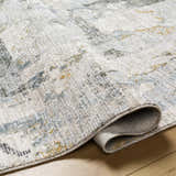Close-up of the Adlai Textured Rug showing the light gray, ink blue, and mustard colors and textured weave. Fold
