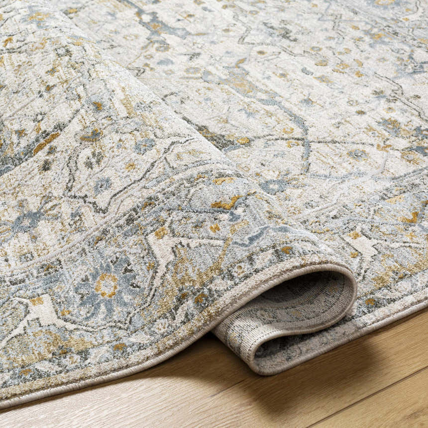 Close-up of the Aviva Off-White Textured Rug showing its light gray, taupe, and mustard traditional design and soft polyester texture. Fold