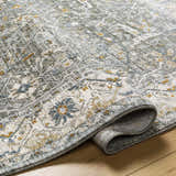 Close-up of the Aviva Teal Textured Rug showing its traditional floral pattern, fringe detail, and soft color palette. Fold