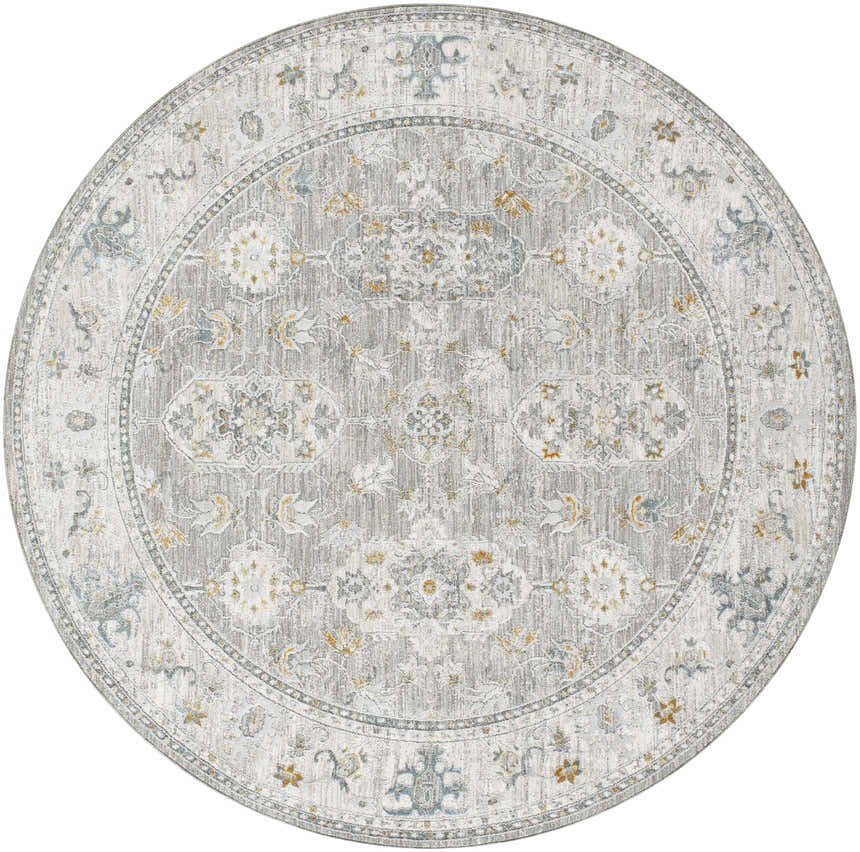 Close-up of the round Hafsa Textured Rug. Gray, nutmeg, and blue floral pattern on a light gray background. Design-Round