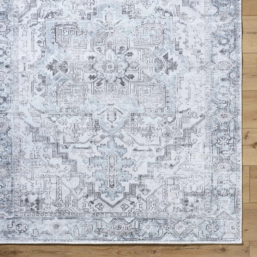 Close-up of Nadia Silver Gray Area Rug, showing traditional light purple, silver gray pattern and machine woven texture. Corner