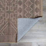 Close-up of the Halle Beige Washable Area Rug showing its geometric pattern and brown, gray, and oatmeal color palette. Fold