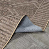 Close-up of the woven texture and backing of the Halle Beige Washable Area Rug, in dark brown, gray, and oatmeal hues. Fold