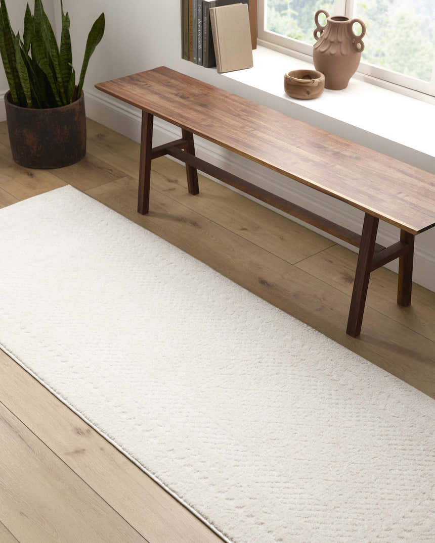 Entryway with light wood floors and Julio Ivory Area Rug. Wooden bench sits by the window. Roomscene-Runner