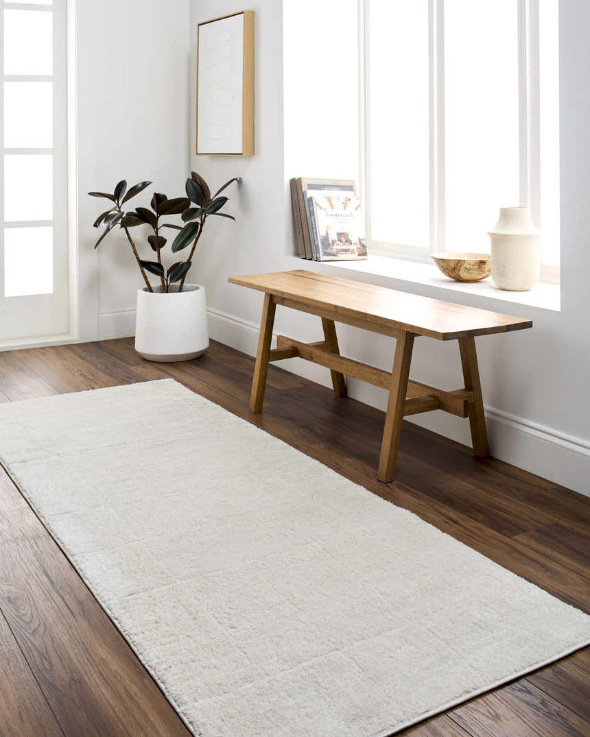 Bright entryway with a Keanu Ivory runner rug, wood bench, and indoor plant. Roomscene-Runner