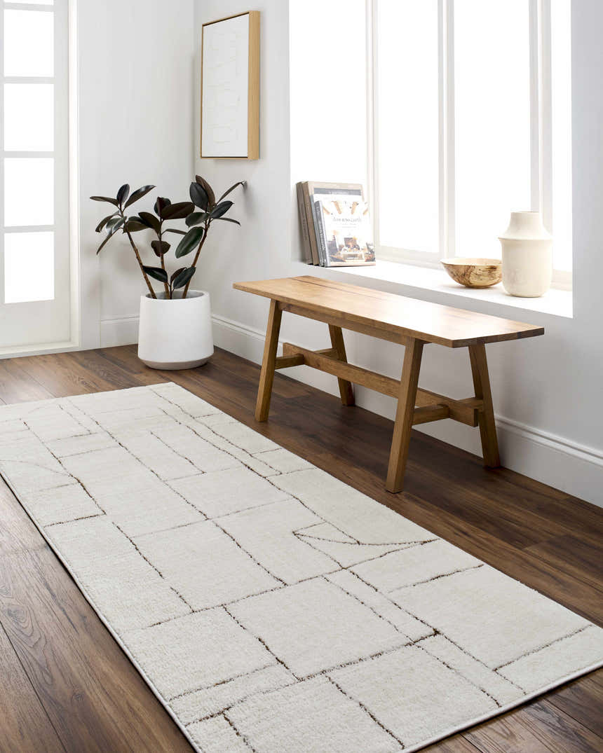 Bright entryway with a beige Keats Area Rug, wood bench, and white accents. Roomscene-Runner