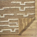 Close-up of the hand woven Miya Area Rug showing the jute texture and beige geometric pattern. Fold