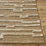 Close-up of the hand woven Miya Area Rug. Jute rug with beige geometric pattern and natural texture on wood floor. Front