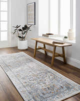 Hallway scene with a Hewez Area Rug in cloud gray and brown, bench, plant, and bright light. Roomscene-Runner