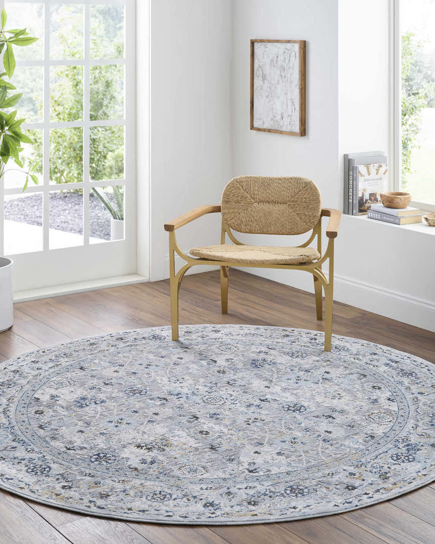Light and airy room with round Irida Area Rug in dark gray, denim, and gray under a modern chair. Roomscene-Round