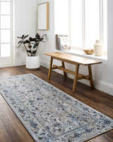 Entryway with a light gray and denim Irida Area Rug, wood bench, and potted plant. Roomscene-Runner