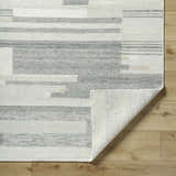 Close-up of Fadri Area Rug. Beige and ivory wool rug with contemporary geometric pattern and hand-knotted texture. Fold
