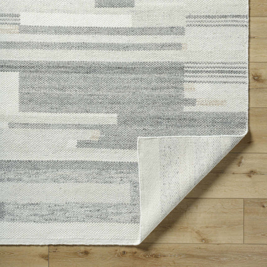Close-up of Fadri Area Rug. Beige and ivory wool rug with contemporary geometric pattern and hand-knotted texture. Fold