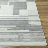 Close-up of the Fadri Area Rug. Hand-knotted wool rug with a geometric pattern in beige, ivory, light beige, and taupe. Front