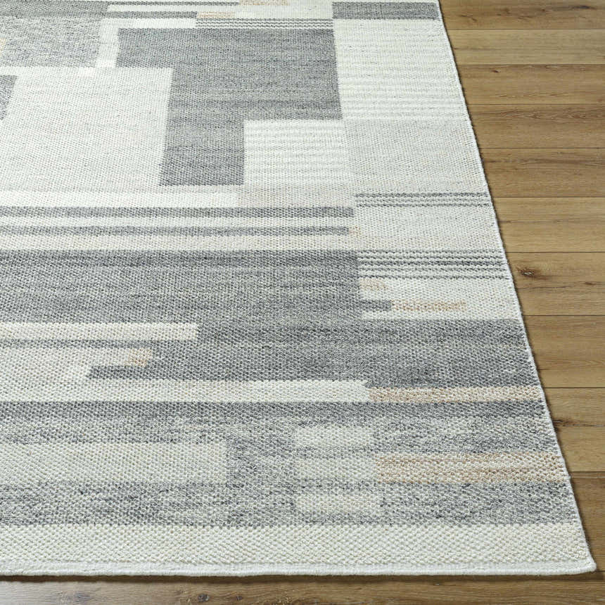 Close-up of the Fadri Area Rug. Hand-knotted wool rug with a geometric pattern in beige, ivory, light beige, and taupe. Front