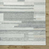 Close up of the Fadri Area Rug. Beige, ivory, and taupe wool rug with a geometric, mid-century modern design. Hand knotted texture. Corner
