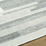 Close up of the hand knotted Fadri Area Rug. Beige and ivory geometric pattern in 100% wool. Texture