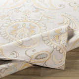 Close-up of Simpatico Candice Olson x LIVABLISS SPO-1001 rug. Cream wool rug with light blue, mustard, and ivory paisley pattern. Fold