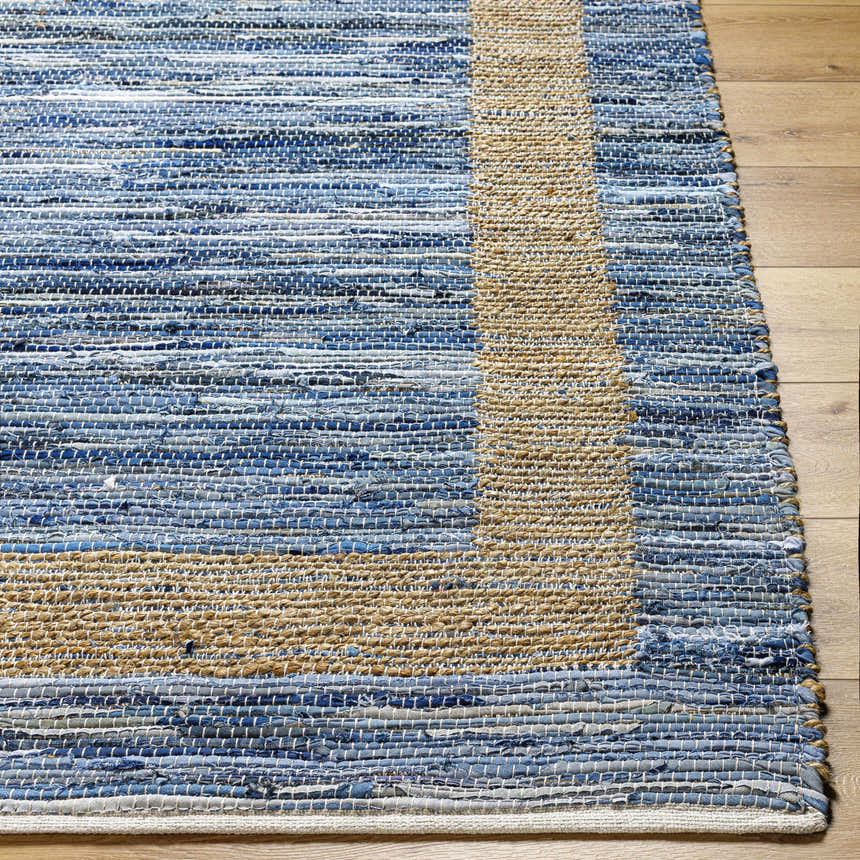 Close-up of the hand woven Ghita Recycled Blue Jean Rug. Features beige border and horizontal blue jean stripes. Front