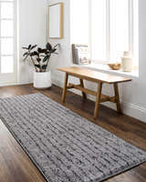 Entryway with Demi Gray Washable Area Rug, wood bench, and plant. Bright, minimalist decor. Roomscene-Runner