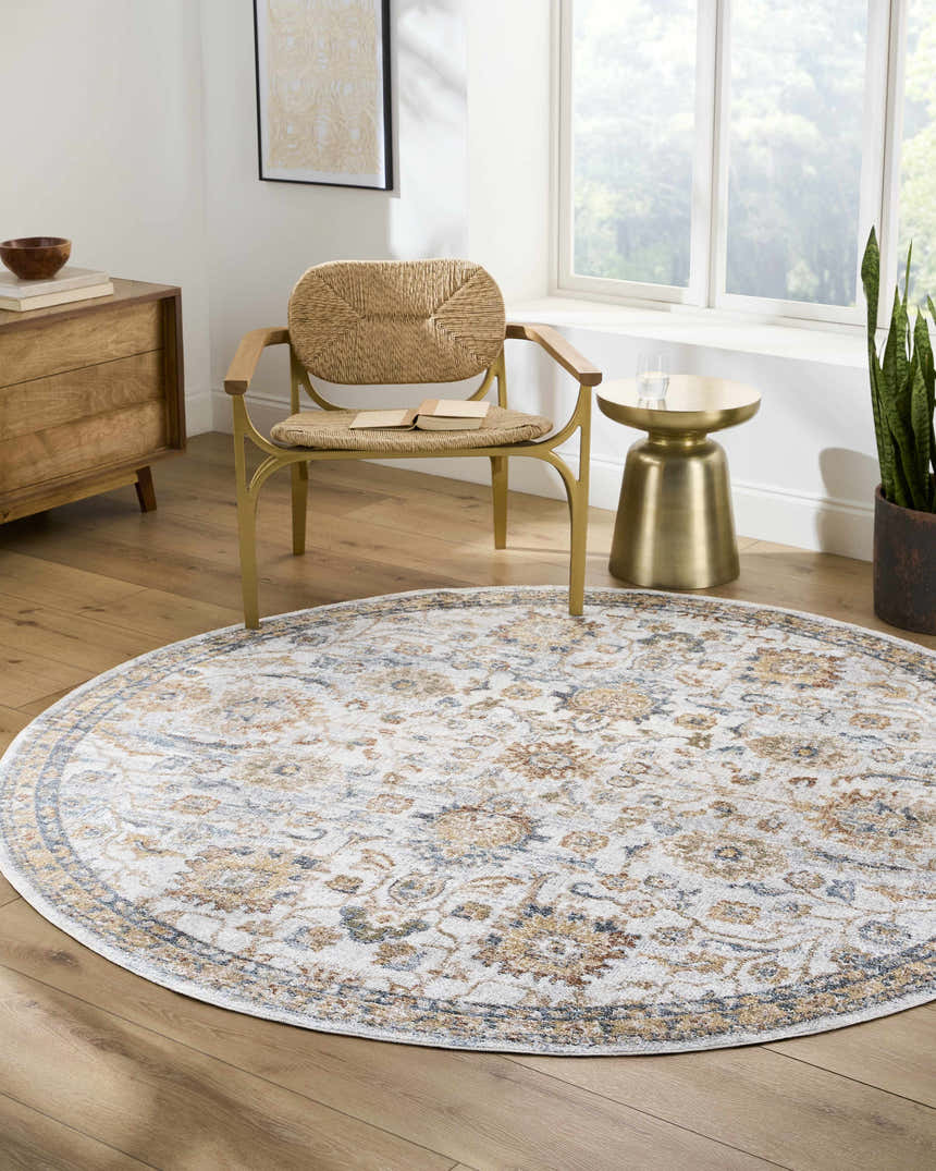 Living room scene with a round Dion Washable Floral Rug in driftwood, beige, and gray colors, under a chair. Roomscene-Round