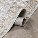 Close-up of the Dion Washable Floral Rug showing its charcoal, beige, and blue traditional pattern and soft texture. Fold