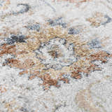 Close-up of the Dion Washable Floral Rug. Features a traditional floral pattern in charcoal, beige, and blue tones. Texture