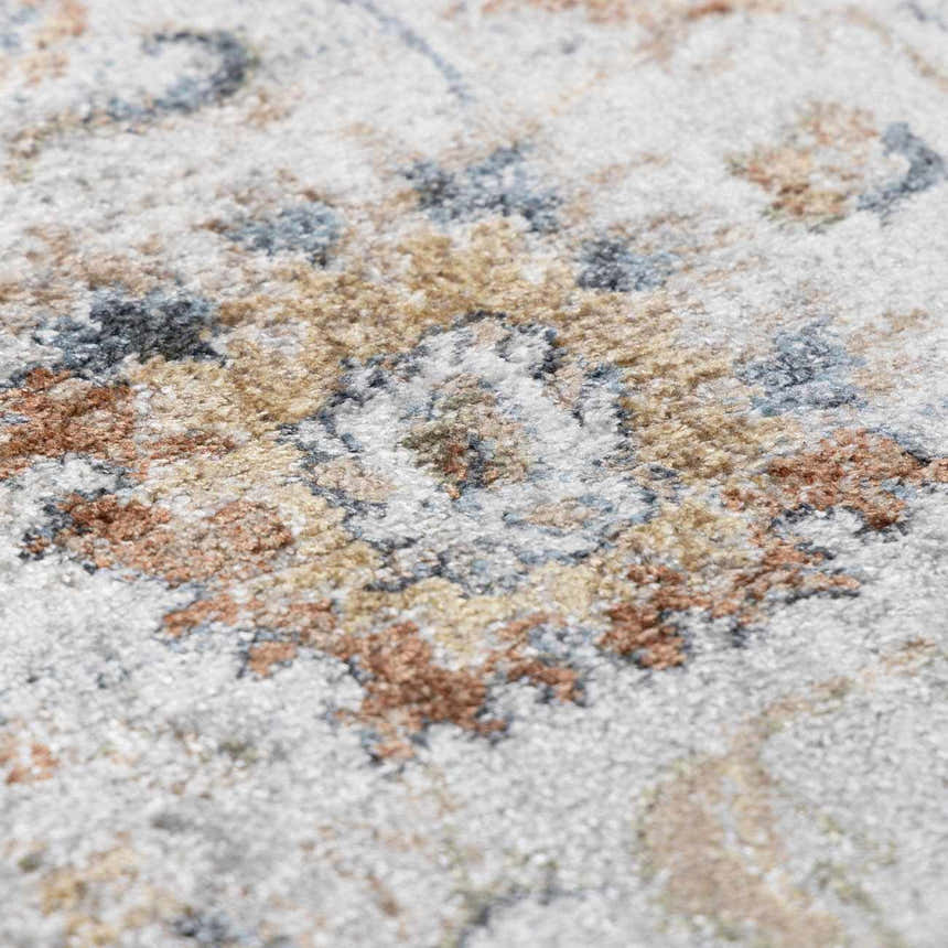 Close-up of the Dion Washable Floral Rug. Features a traditional floral pattern in charcoal, beige, and blue tones. Texture